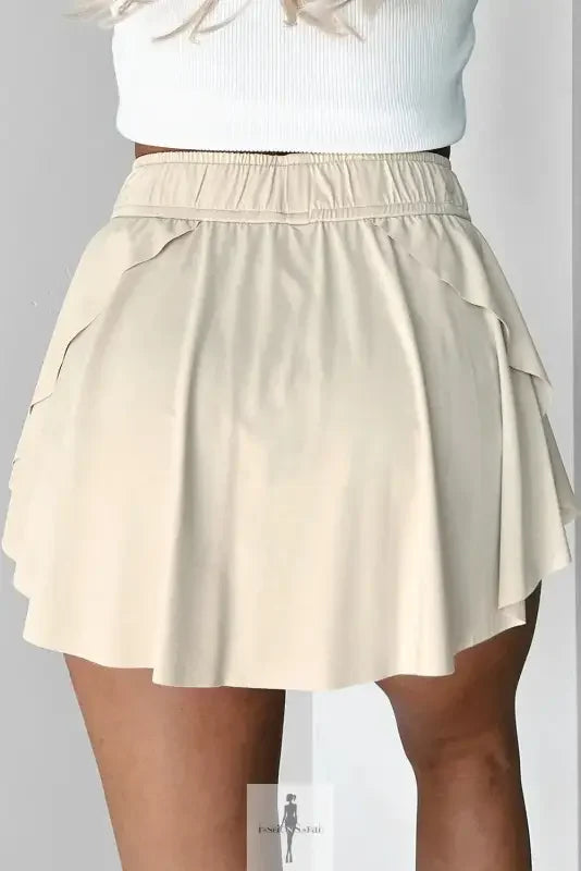 Beige drawstring high waist mini skirt with tiered design and lined tennis style