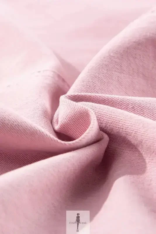 Wrinkled pink fabric detail from a Pink Denim Romper with Pockets, showcasing denim texture