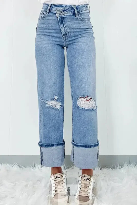Blue high rise ripped jeans with cuffs and distressed detailing for a trendy look