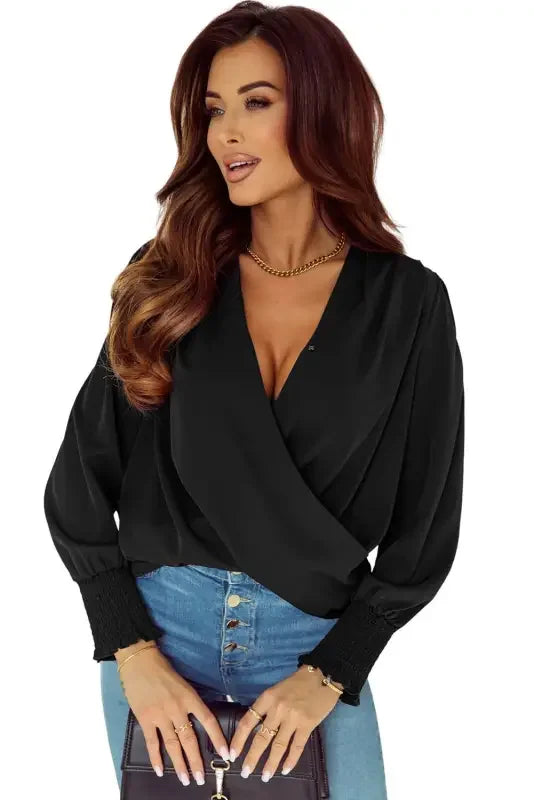 Woman in black shirred cuffs draped blouse with solid surplice neck for elegant style