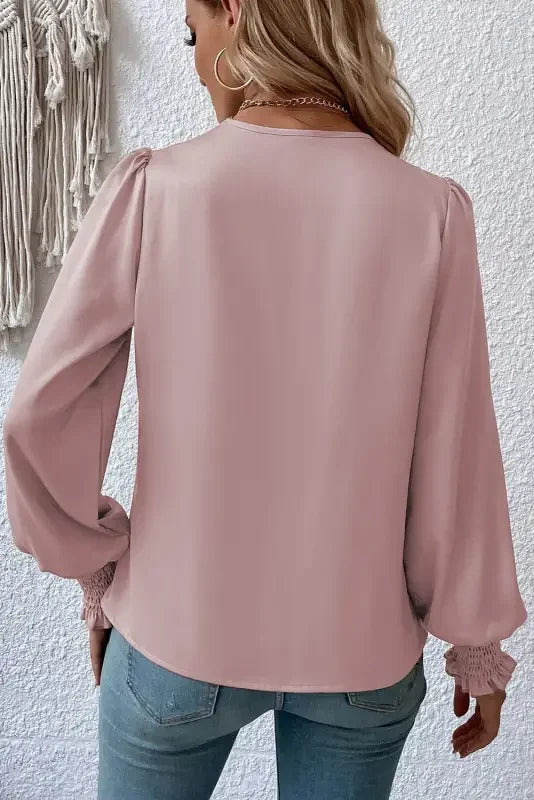 Pink long-sleeved blouse with solid surplice neck and shirred cuffs draped design