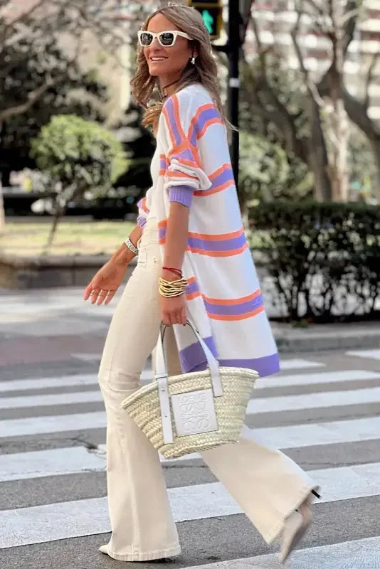 Multicolor striped cardigan paired with a straw tote bag for casual style elegance