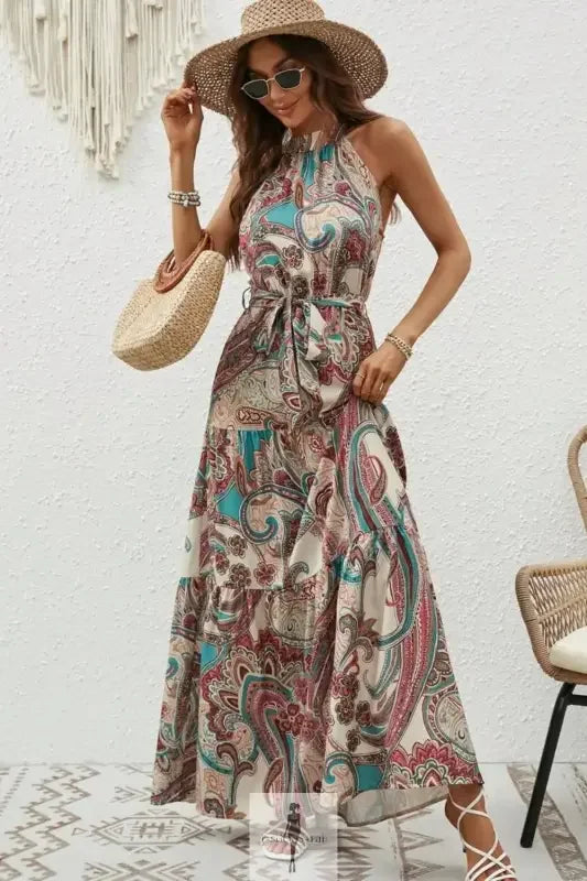 Woman wearing a tied floral sleeveless dress in a paisley halter maxi style