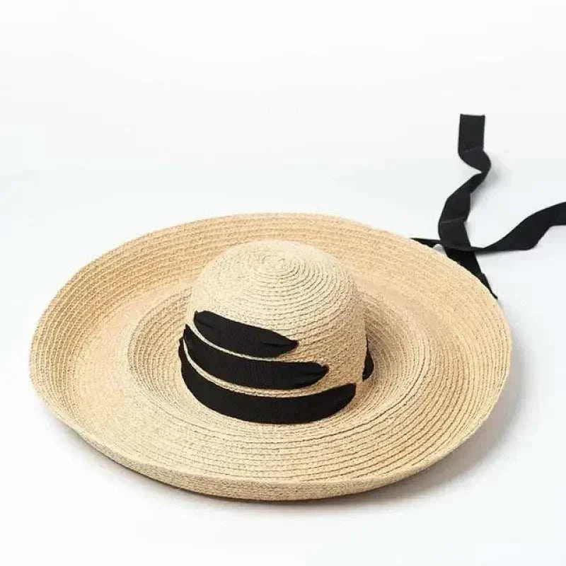 Wide brim beach hat made of straw raffia with black ribbon detailing