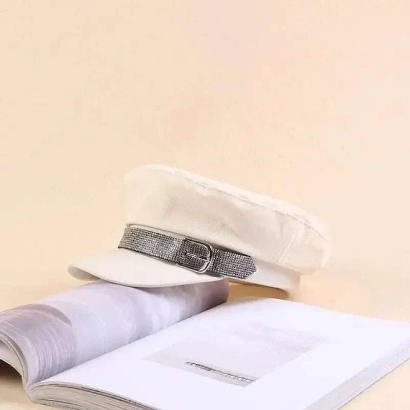 White rhinestone cadet hat made of cotton with decorative band and 8cm brim displayed on an open book