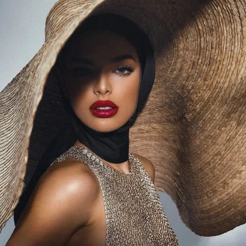 Glamorous woman wearing fashionsarah oversized straw hat for stylish sun protection
