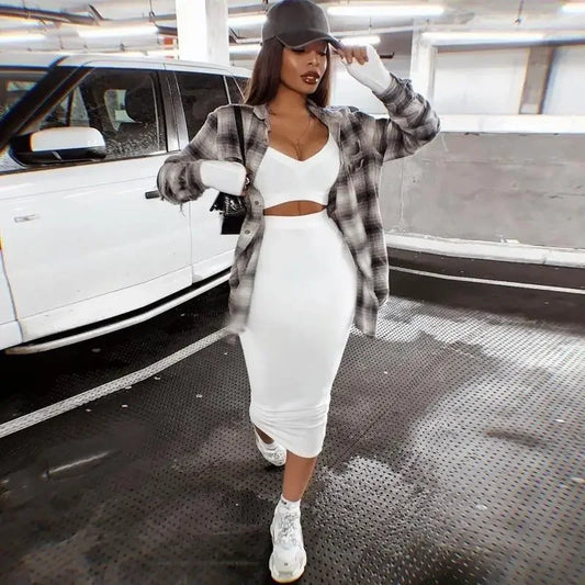 Stylish woman in white outfit with plaid shirt and patterned handbag at online boutique