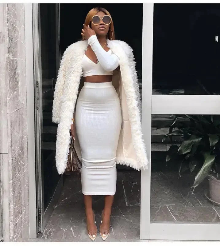 Woman in white outfit with furry coat and patterned handbag showcasing women’s fashion from online boutique