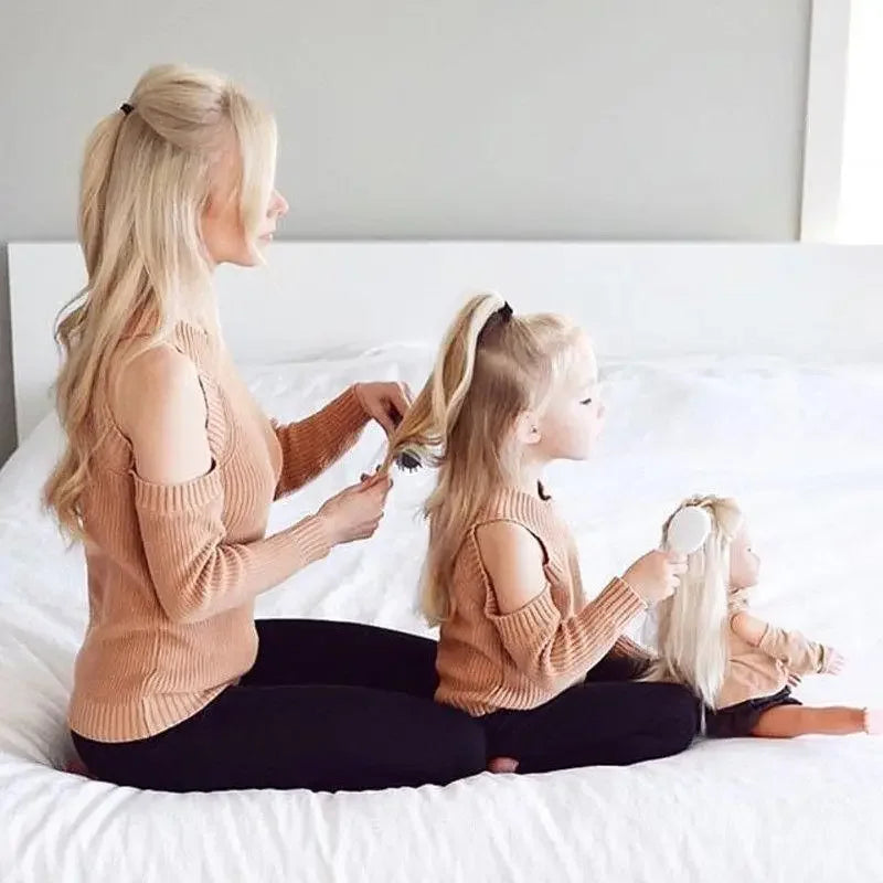 Matching mother daughter sweaters featuring coordinated hair styling for a cute family look