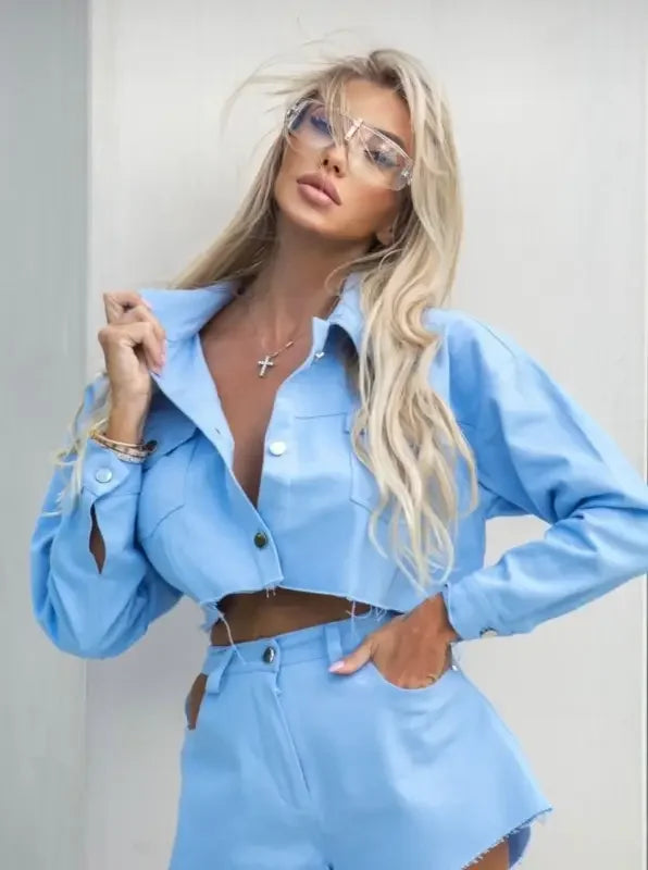 Light blue cropped jacket and shorts set with black frameless retro sunglasses