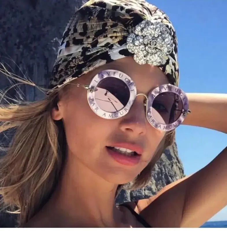 Woman wearing stylish round sunglasses and a turban in a fashion portrait image