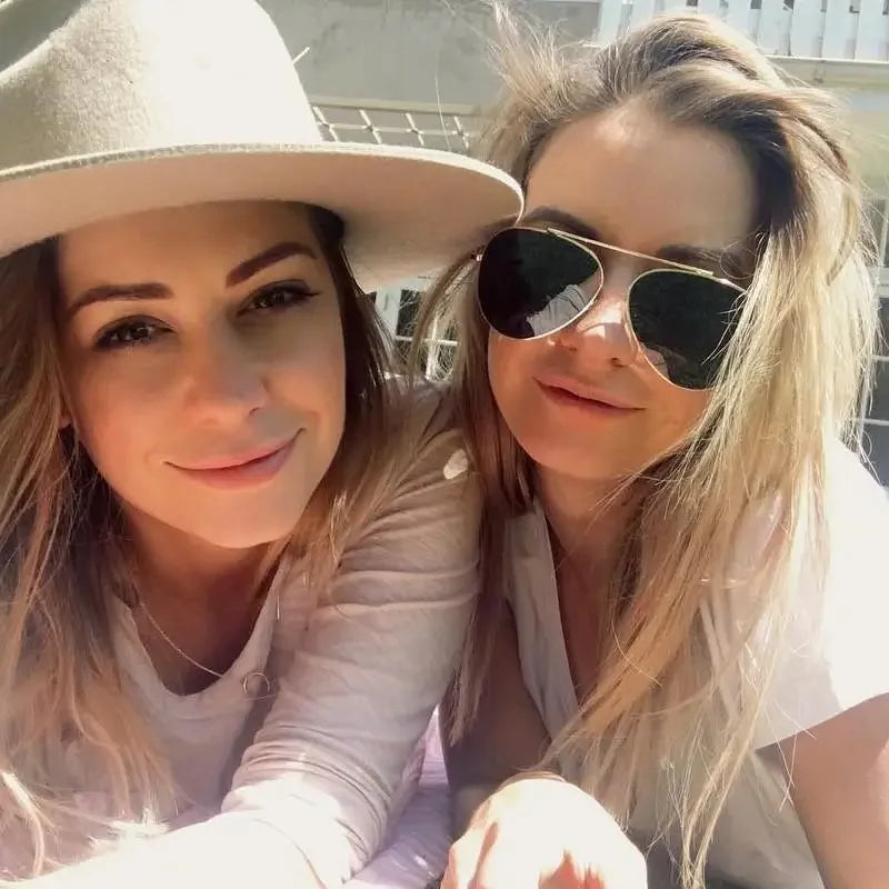Two blonde women wearing Gold Aviator Pilot Mirror Sunglasses with pink lenses