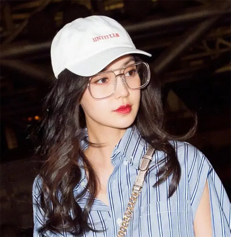White baseball cap complementing oversized retro sunglasses in a stylish retro look