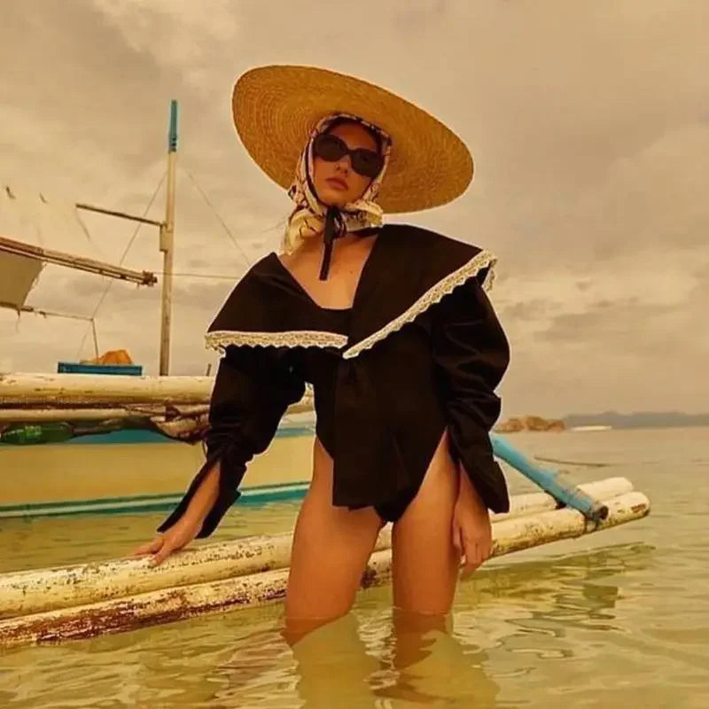 Woman in black swimsuit wearing a wide brim straw hat for elegant summer style