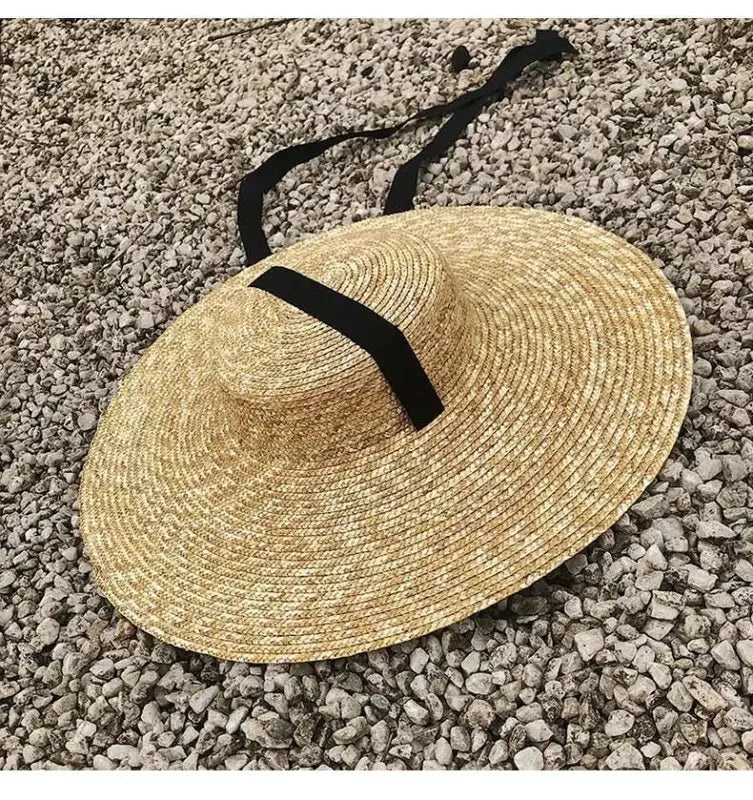 Wide brim straw hat with black ribbon, perfect for stylish sun protection
