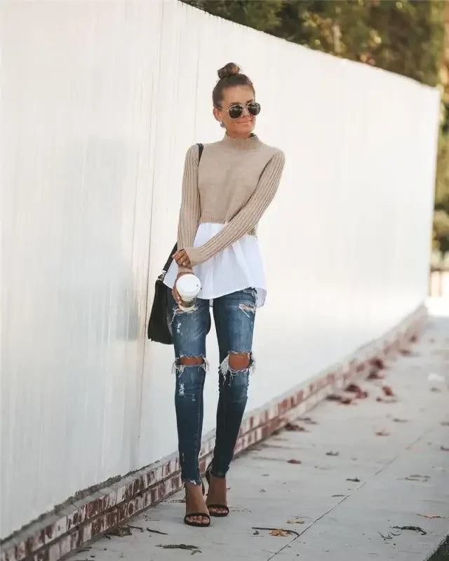Stylish woman in ripped jeans wearing a chic layered knit sweater shirt look