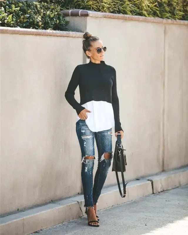 Woman in ripped jeans wearing a chic layered knit sweater shirt for stylish fall look