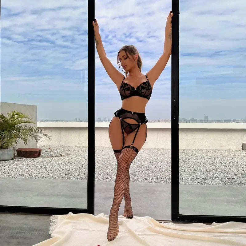 Woman wearing luxury transparent set 3-pieces hot lingerie bodysuit and fishnet stockings