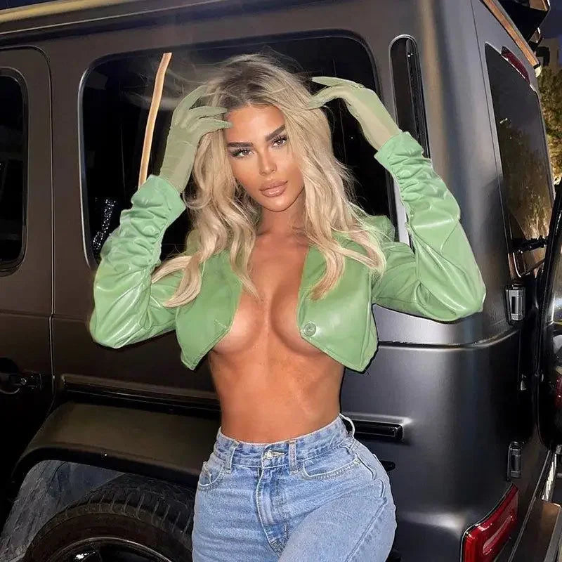 Woman in green jacket and jeans wearing the Leather Irregular Crop Jacket for a stylish look