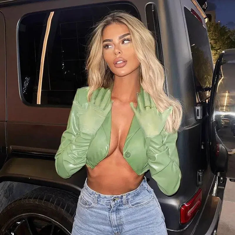 Woman in green jacket and jeans wearing a stylish leather irregular crop jacket