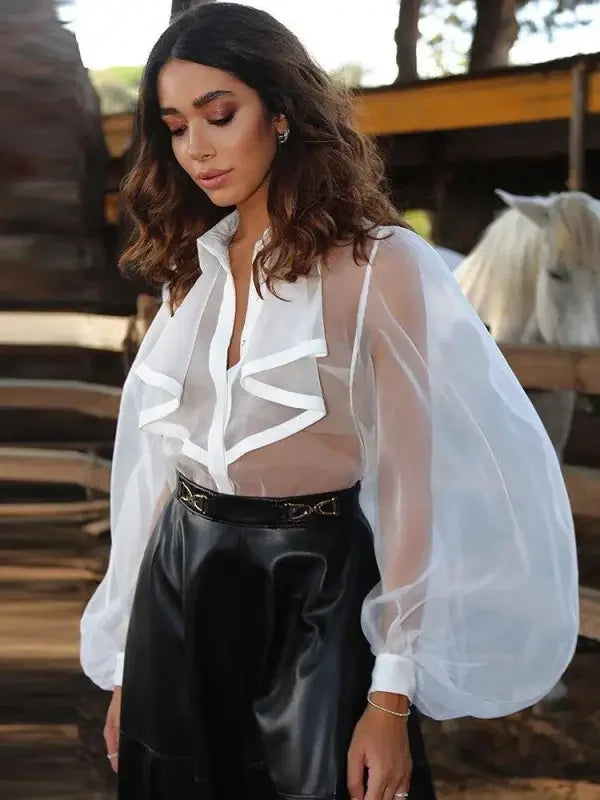Woman wearing ruffles turndown collar loose bodysuit in sheer white blouse and black skirt