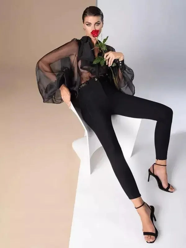 Woman in sheer black blouse with ruffles turndown collar and loose fit Bodysuit