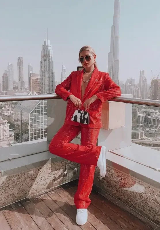 Woman wearing a red fashion sequin blazer and straight trousers showcasing elegant style