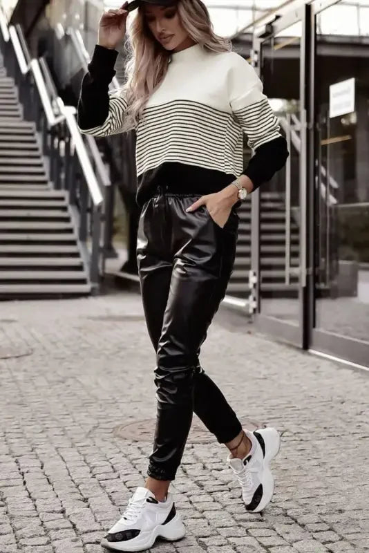 Woman wearing black striped contrast colorblock knit top with stylish casual outfit